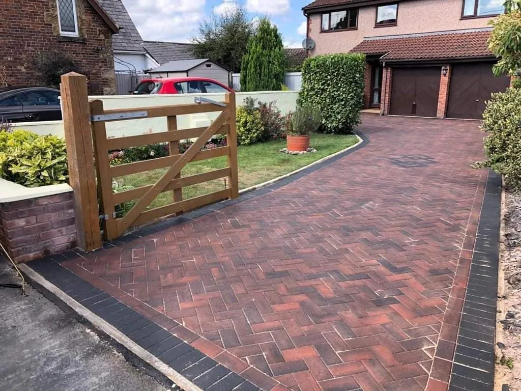Herringbone block paving driveway with wooden gate installed by A.L. Landscapes in Manchester