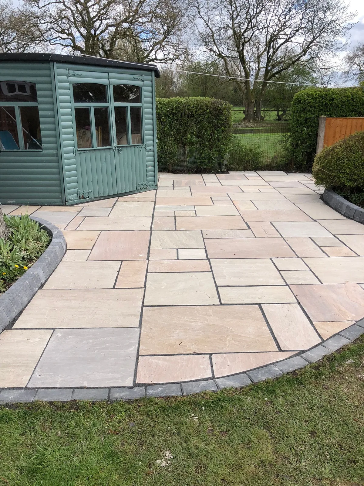 Indian sandstone patio with curved border in Manchester